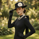 Load image into Gallery viewer, icevellyyy elegant black velvet evening dress with long sleeves and a dramatic back bow detail, styled with pearls and gloves.