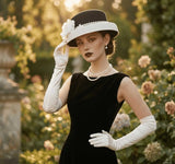 Load image into Gallery viewer, Elegant icevellyyy black and white wide brim fascinator hat with floral embellishment and pearl details. A woman wears it with a black dress and white gloves.