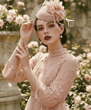 Load image into Gallery viewer, icevellyyy blush pink lace midi dress with high neck, long embroidered sleeves, and floral details. Model wears a matching fascinator.